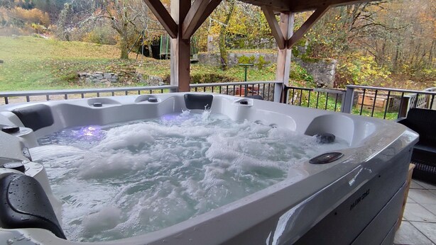 Un jacuzzi con vistas a una zona verde y árboles.
