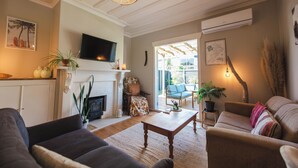 Un salon avec une cheminée, un canapé et un téléviseur.