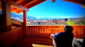 A wooden balcony with a view of a town and mountains. - 5* Lory vacation apartment with castle and panoramic views (Halblech)