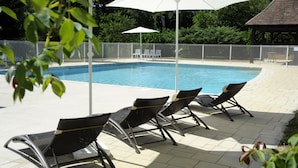 A swimming pool with lounge chairs and umbrellas. - Apartment n°2 (T3) two bedrooms with terrace ground floor (Saint-Vincent-de-Cosse)