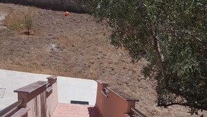 Una escalera con barandilla metálica que lleva a una zona cubierta.