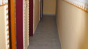 A narrow hallway with doors on both sides, each with a decorative trim.