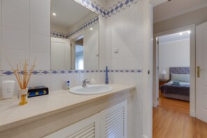 Een badkamer met een wastafel, spiegel en decoratieve tegels.