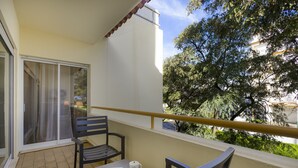 A balcony with a table, chairs, and a book. - Jazz & Silvia (Albufeira)