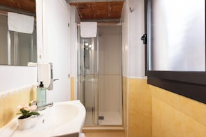 A bathroom with a shower, sink, and mirror.