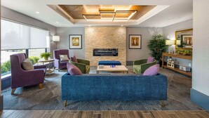 Een moderne lounge met een stenen muur, comfortabele zitplaatsen en een flatscreen televisie.