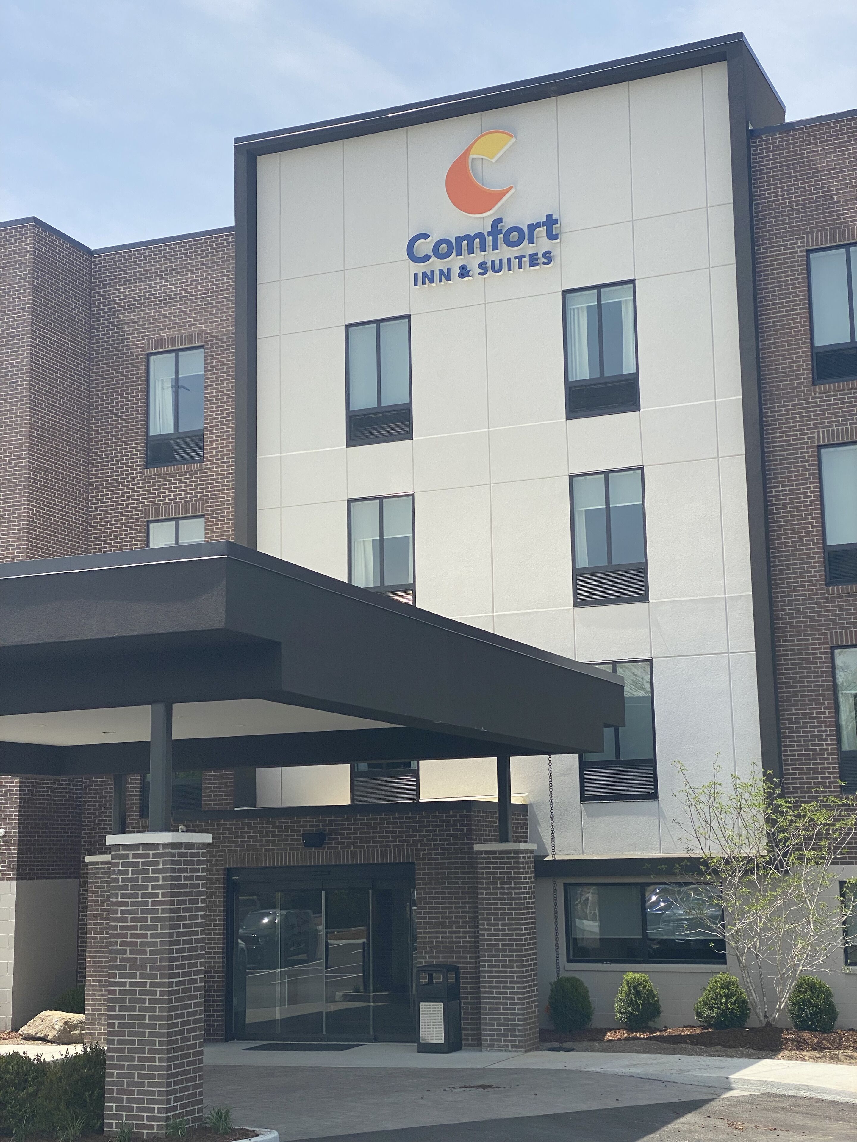 Ein Comfort Inn & Suites Gebäude mit modernem Design, das ein gut sichtbares Logo an der Fassade zeigt.