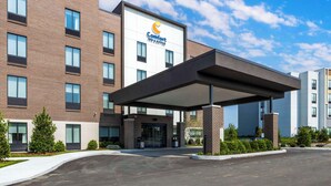 Een Comfort Inn & Suites hotel met een gevel van baksteen, grote ramen en een overdekte ingang.
