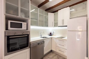 A modern kitchen with a built-in microwave, oven, dishwasher, and refrigerator.