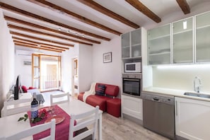 Una cocina compacta equipada con lavavajillas, microondas y un fregadero.
