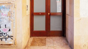 A building entrance with a wooden door and a stone archway. - Ripoll Old Town - Unik Vacation (Tarragona)