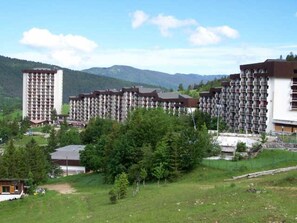 A hotel complex with multiple high-rise buildings, surrounded by greenery and mountains. - Cozy Studio at Balcon de Villard - Parking Included (Villard-de-Lans)