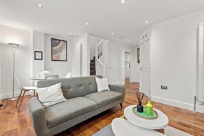 A modern living room with a grey sofa, a round coffee table, and a floor lamp.