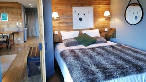 A cozy room with a wooden headboard, a large furry blanket, and a framed picture of a dog on the wall. - Renovated apartment for 4, near slopes in Pra Loup (Pra-Loup)