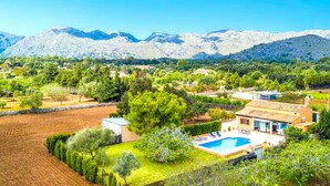 Ein Wohngebiet mit Pool, Häusern und Bergen im Hintergrund.