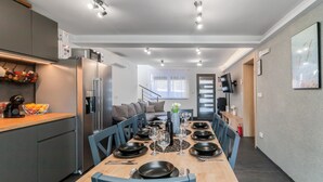 Une cuisine moderne avec un coin repas aménagé pour accueillir six personnes.