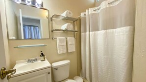 A bathroom with a sink, toilet, and shower curtain.