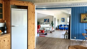 A spacious living area with a wooden floor, a dining area with a piano, and a blue accent wall. - Beautiful home in Farsund with WiFi (Farsund)