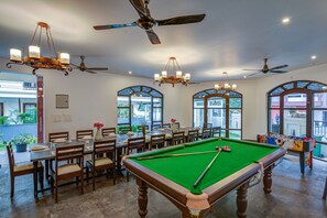 A billiards room with a pool table, multiple ceiling fans, and large windows. - Villa Calangute Phase 17 (Calangute)
