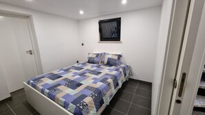 Un dormitorio con cama, ventana y puerta.