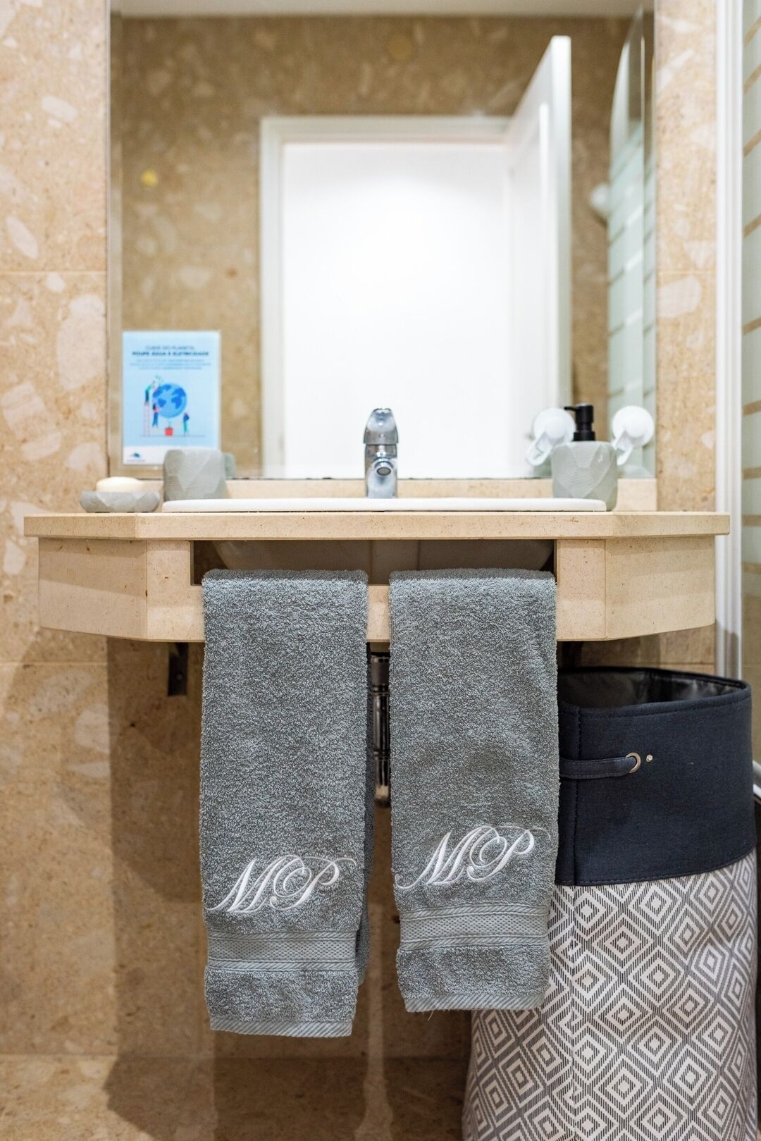 A bathroom with a sink, mirror, and towel rack.
