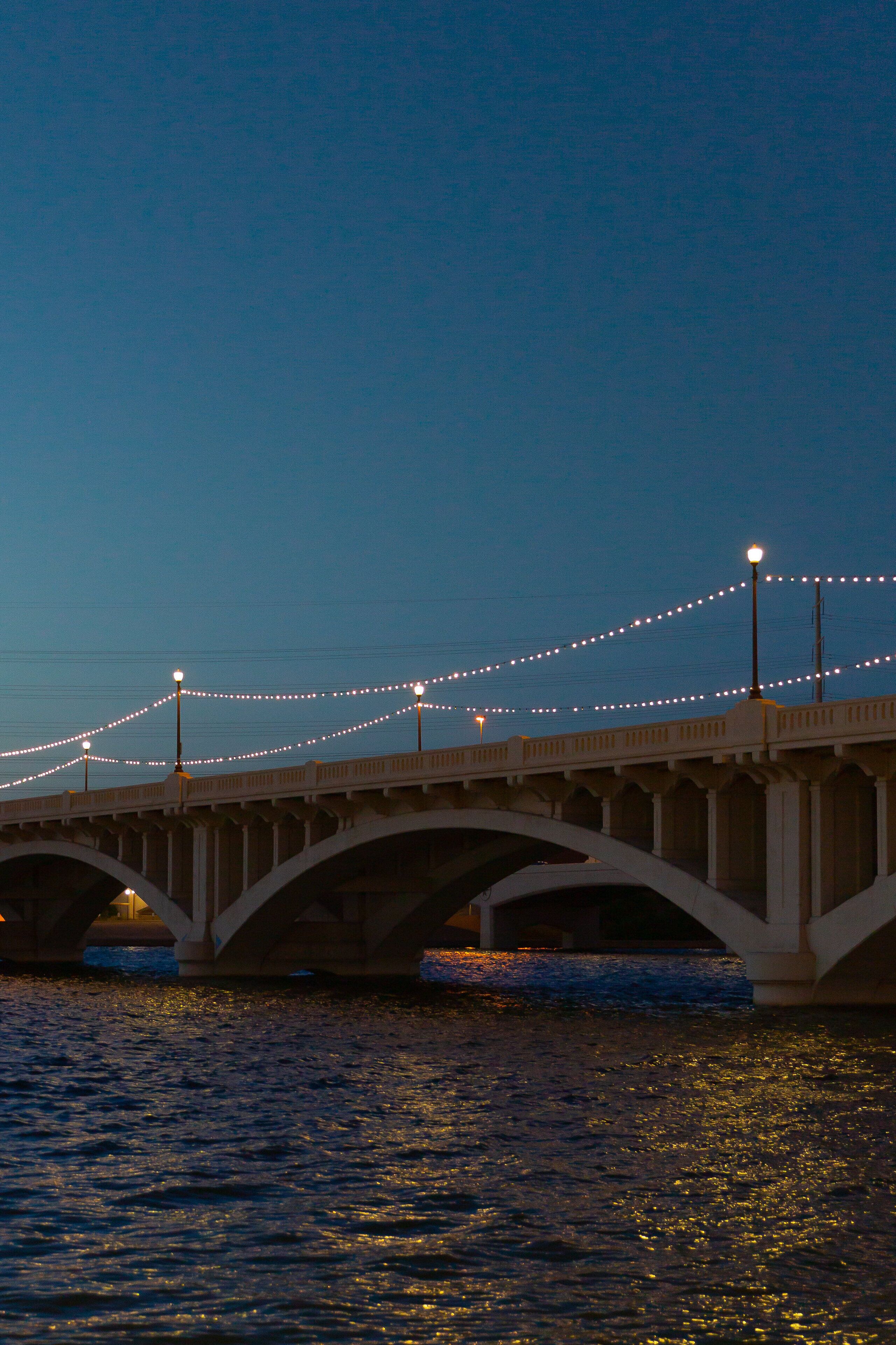 Un puente decorado con luces colgantes y farolas.