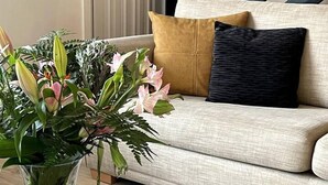 Ein Wohnzimmer mit einer Couch, einem Couchtisch und einer Blumenvase.