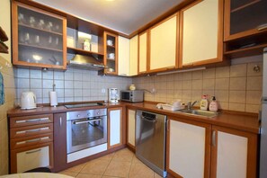 A kitchen with wooden cabinets, a microwave, a coffee maker, and a dishwasher.