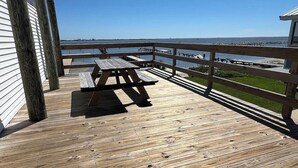 Une terrasse en bois avec une table de pique-nique et une vue sur l’eau.
