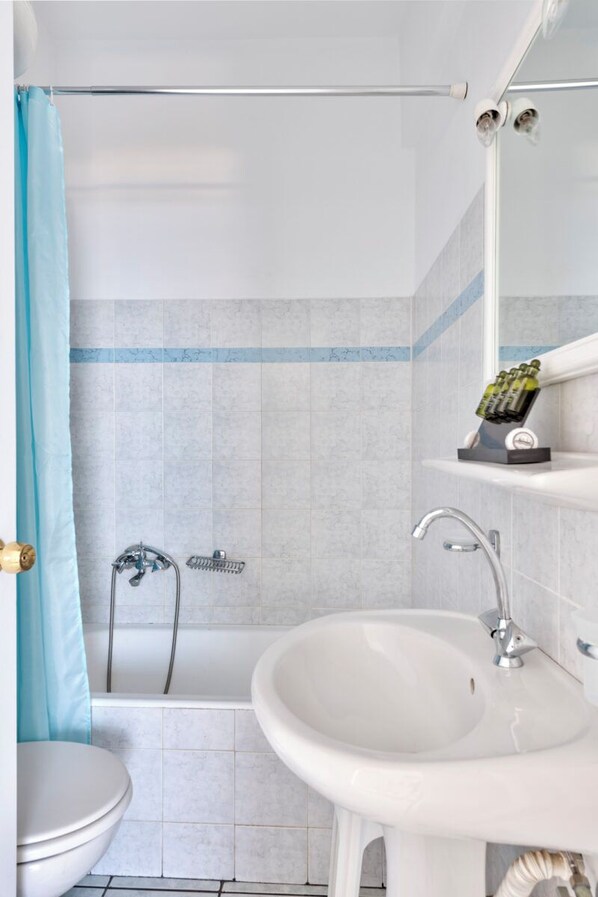 A bathroom with a bathtub, a sink, and a toilet.