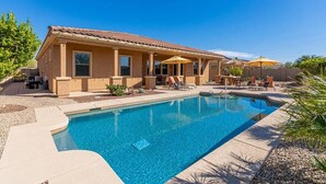 A two-story house with a swimming pool, outdoor furniture, and a covered patio area. - Luxury Stay at Estrella Mountain Ranch (Goodyear)