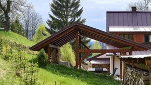Ein modernes Haus mit Holzterrasse und Steinmauer.