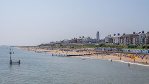 Eine Küstenstadt mit Strand, Häusern und einem Leuchtturm.