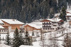A snow-covered mountain resort with wooden buildings and a ski slope.