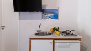 Eine kleine Küche mit Spüle, Herd und einem Schrank.