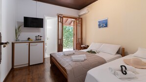 Ein Schlafzimmer mit Bett, Nachttisch, Fernseher und Blick ins Freie.