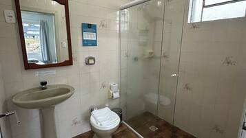 Een badkamer met een wastafel, toilet en douchecabine.