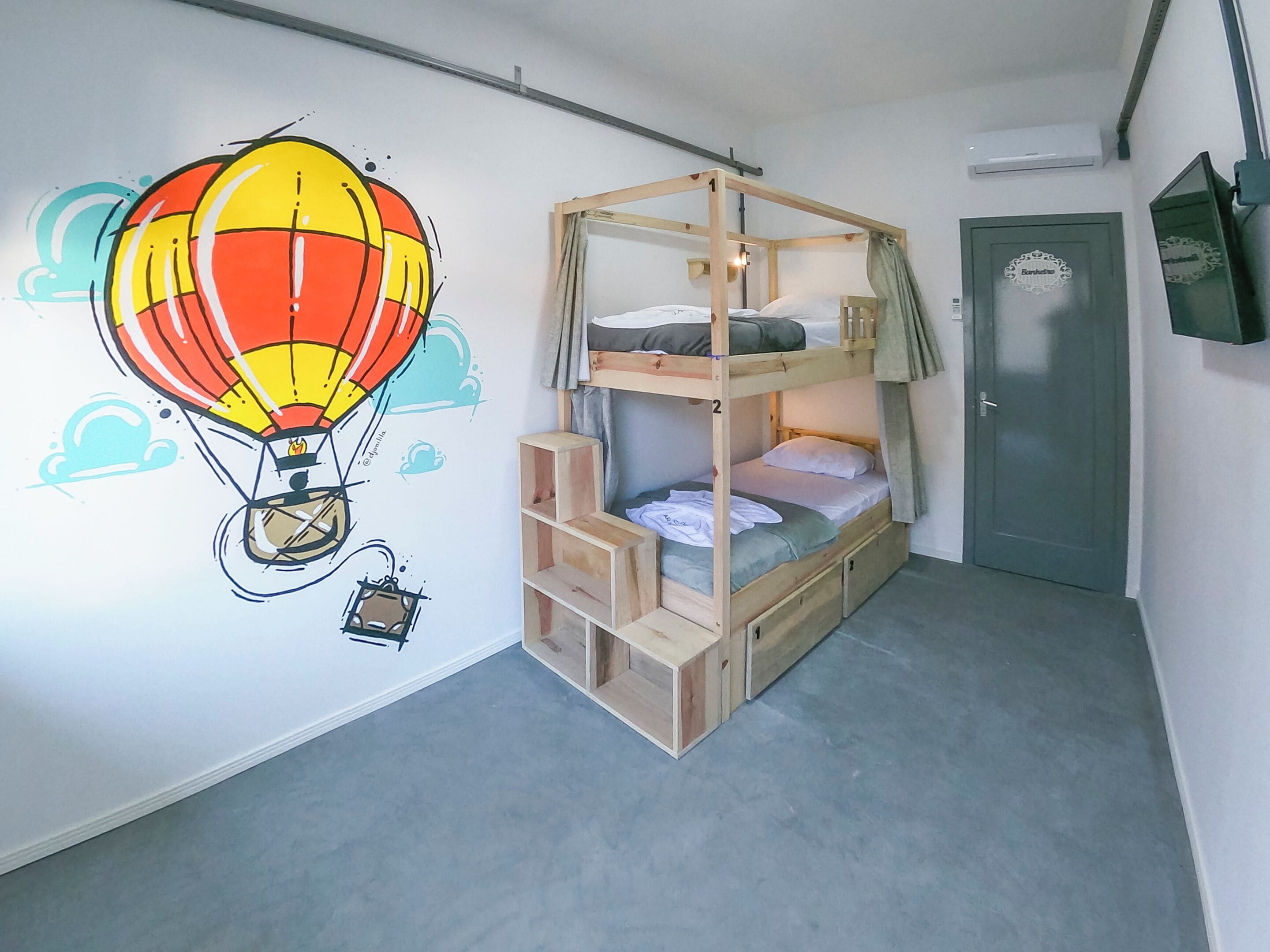 A bunk bed room with a wall mural of a hot air balloon.