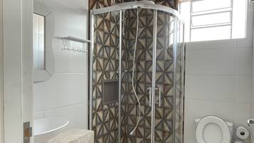 A modern bathroom with a glass-enclosed shower, a white toilet, and a marble vanity.