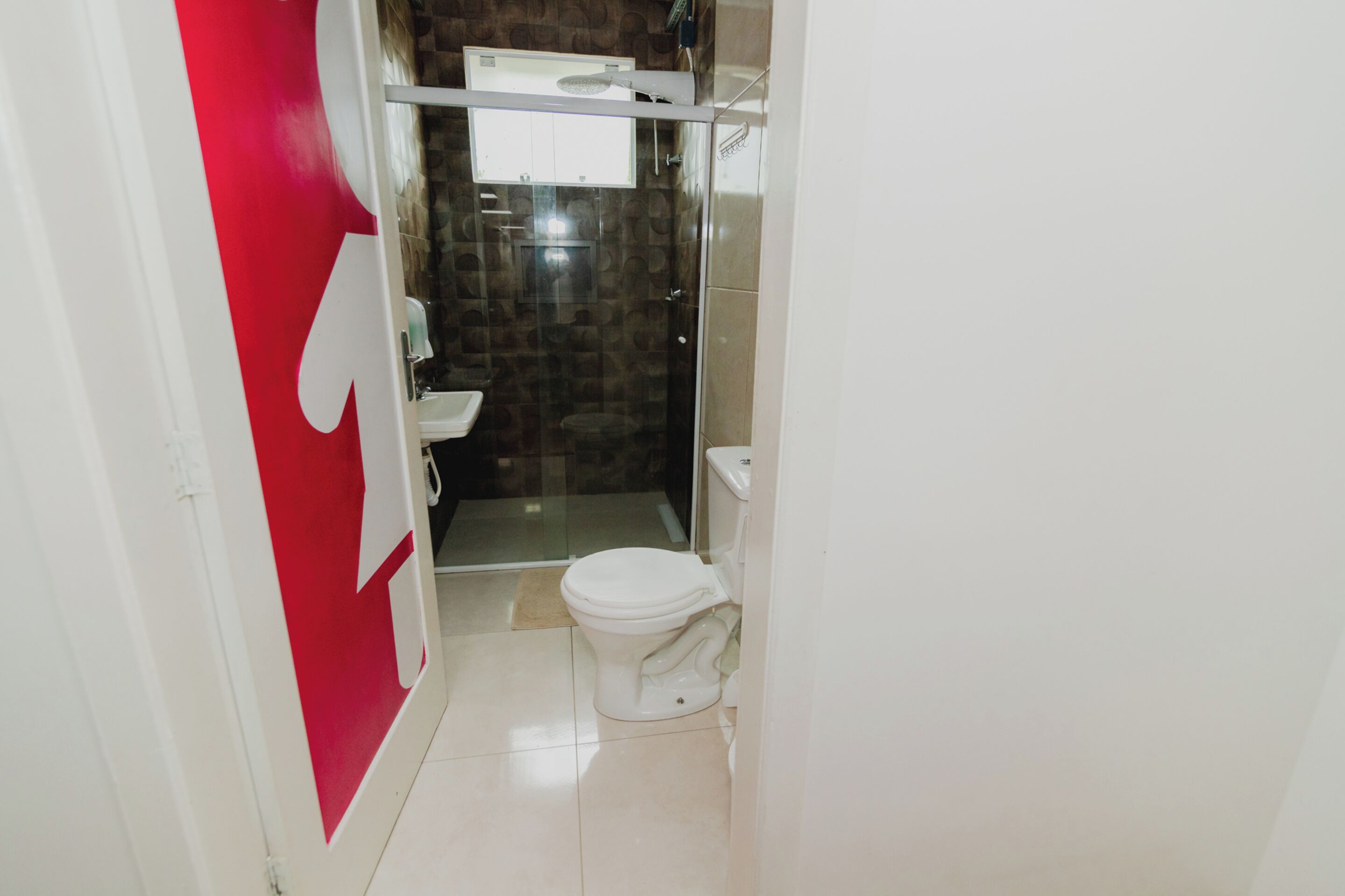 A bathroom with a toilet, a shower, and a sink.
