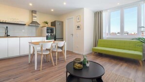 Un apartamento moderno con cocina, comedor y sala de estar con un ventanal grande.