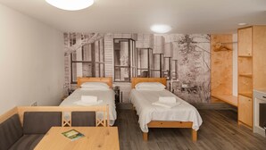A room with two single beds, a wooden table, and a bench. - Elm - Flimwell Park Lodges (Ticehurst)
