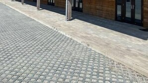 Un edificio con una lunga fila di stanze, ciascuna con porta e finestre, e un porticato.
