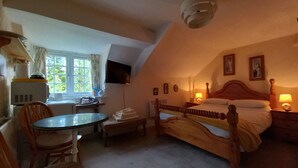 Une chambre à coucher avec un lit, une table de chevet, une lampe et une fenêtre avec des rideaux.