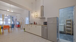 Una cocina moderna con armarios blancos, electrodomésticos de acero inoxidable y un amplio ventanal.
