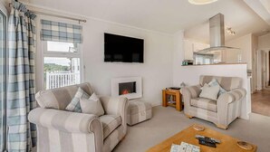 A living room with two sofas, a fireplace, a television, and a wooden coffee table.