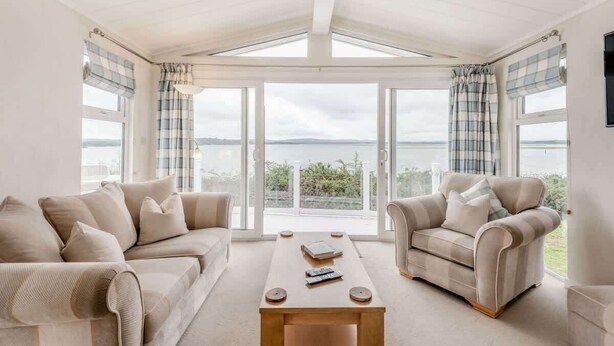 A room with a sofa, armchair, and a coffee table.