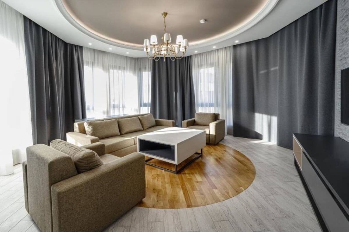 Ein modernes Wohnzimmer mit einem Ecksofa, einem Couchtisch und einem Fernseher.