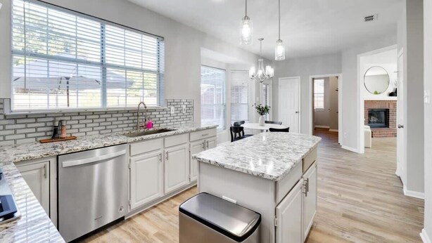 A modern kitchen with a marble countertop, stainless steel appliances, and a central island. - Lewisville Estate - Spacious 5BR w/ Game Room (Lewisville)