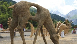 A sculpture of a horse made of hay in an outdoor setting with mountains in the background. - 1st floor, parking, 26m², Valloire (Valloire)